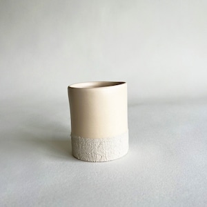 Handgemaakte beige keramische koffiekop: rustiek steengoed met textuur