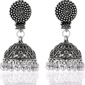 May include: A pair of silver-colored jhumka earrings. Each earring features a round, textured top, a bell-shaped body with geometric patterns, and small dangling beads at the bottom. The earrings are designed with an antique or vintage aesthetic.