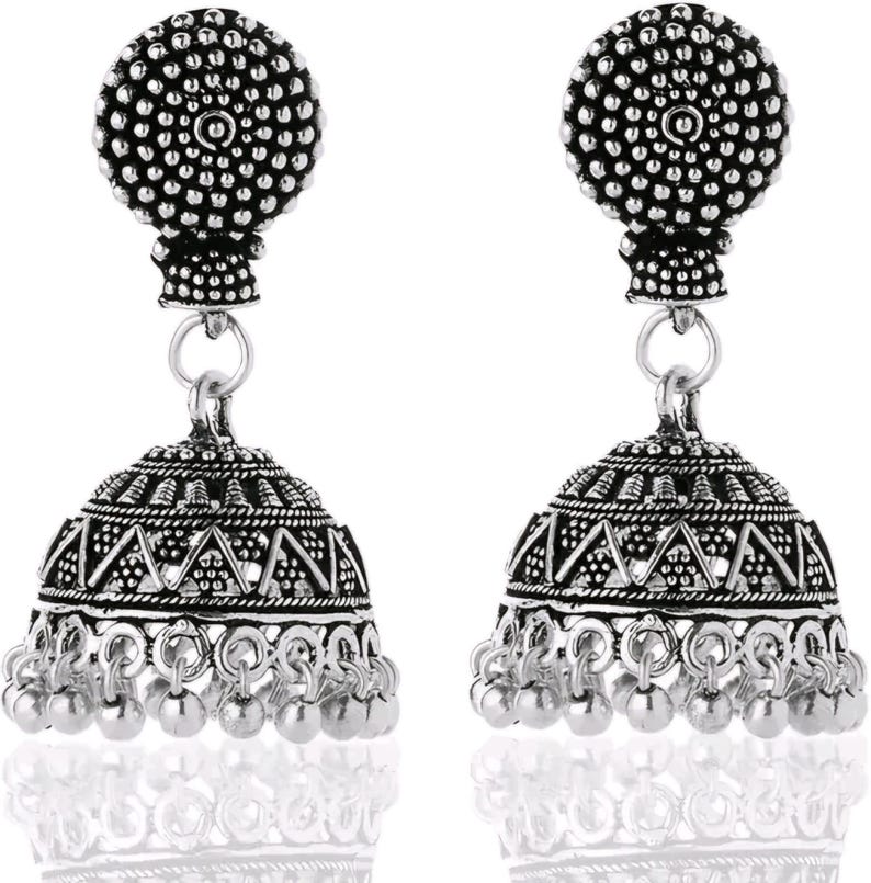 May include: A pair of silver-colored jhumka earrings. Each earring features a round, textured top, a bell-shaped body with geometric patterns, and small dangling beads at the bottom. The earrings are designed with an antique or vintage aesthetic.