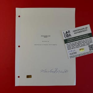 以下が含まれることがあります： ジョン・ミリアスとフランシス・フォード・コッポラによって書かれた『地獄の黙示録 特別完全版』の白い脚本ページ。マーロン・ブランドの署名入り。文書には3つのバインダー穴、ホログラムステッカー、真正証明書が含まれています。