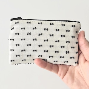 Monedero pequeño con cremallera en negro y crema, bolso de mano minimalista y organizador de bolsos.