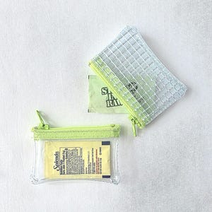 May include: Two small rectangular zipper pouches with lime green trim. One pouch is made of clear plastic containing a yellow Splenda packet. The other pouch is made of a translucent white grid-patterned material containing a green Sugar In The Raw packet.