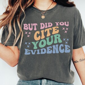 a woman wearing a t - shirt that says but did you cite your evidence?