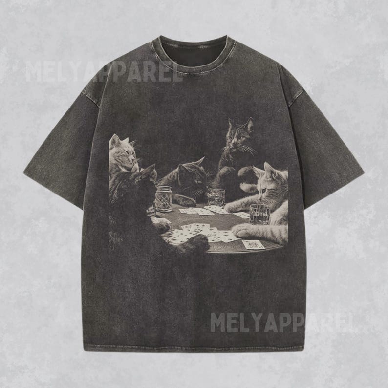 Puede incluir: Camiseta gris oscuro con un gr&aacute;fico en blanco y negro de gatos jugando al p&oacute;quer. La imagen muestra cinco gatos alrededor de una mesa con cartas y bebidas. La camiseta tiene un aspecto vintage y desgastado.
