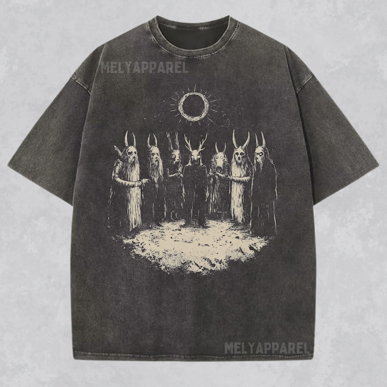 May include: A black t-shirt with a vintage-style graphic print of a group of figures with horns and a sun with a circle in the middle. The text "MELYAPPAREL" is printed on the shirt.