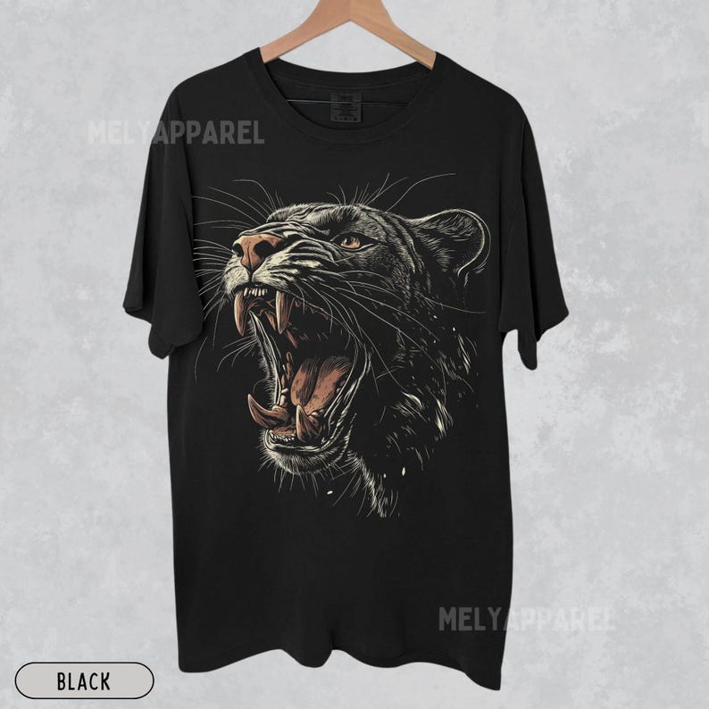 May include: Black t-shirt with a graphic print of a roaring black panther. The panther's mouth is open, showing its teeth and tongue. The graphic is detailed and realistic.