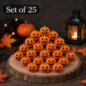 May include: A set of 25 small orange plastic pumpkins arranged in a pyramid shape. Each pumpkin features a carved jack-o'-lantern face with black eyes, a triangular nose, and a jagged mouth. The pumpkins have green stems and a smooth finish.