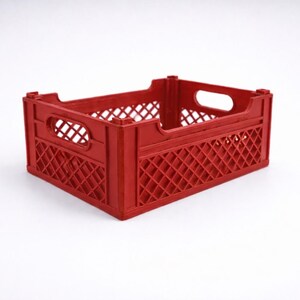 May include: A red plastic storage crate with a lattice pattern. The crate has a rectangular shape with handle openings on the sides. It is suitable for carrying items. The crate is made of durable plastic.