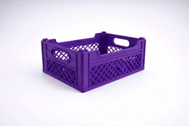 May include: A purple plastic crate with a rectangular form. The crate features a lattice design on its sides and a handle opening at each end. The crate is designed for storage and transport.