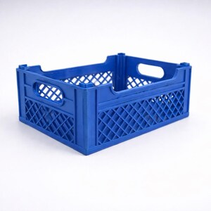 May include: A blue plastic storage crate. It features a lattice pattern on the sides and handle cutouts. The crate is designed for carrying and storing items, with dimensions suitable for various uses.