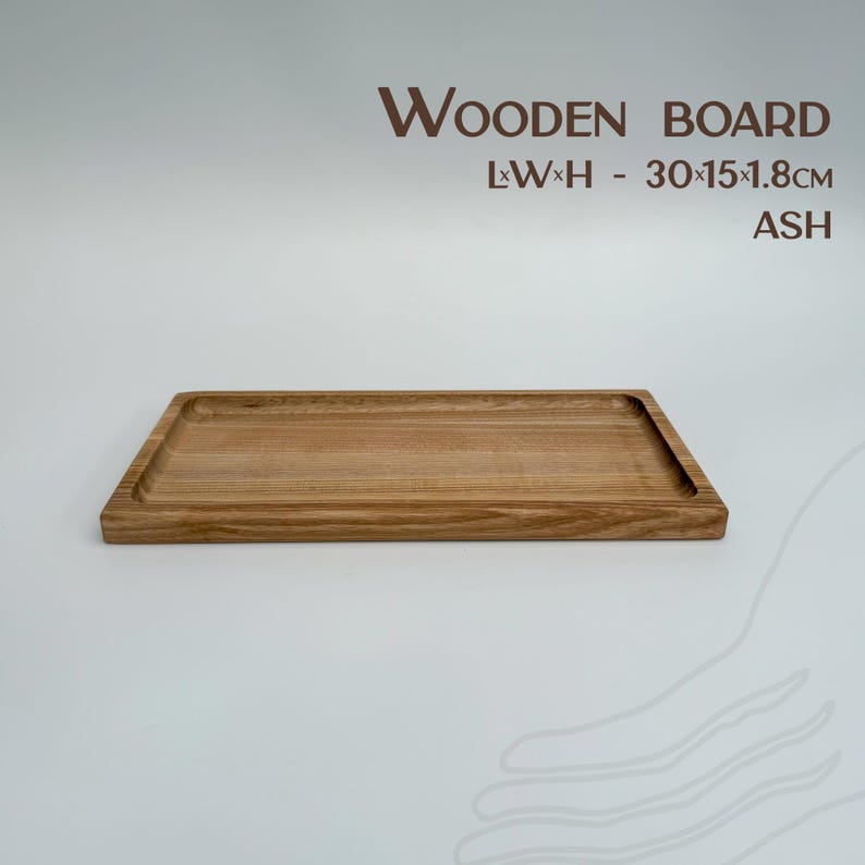 May include: A rectangular wooden serving board made of ash wood. The board measures 30 x 15 x 1.8 inches.  WOODEN BOARD L*W*H - 30*15*1.8CM ASH