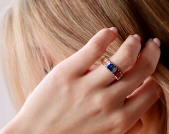 May include: A silver ring with a rainbow of colorful baguette-shaped stones.