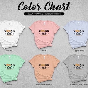 May include: Color chart showing six different Bella + Canvas 3001 light t-shirts in various colors. Each shirt features a graphic design with the text "Cookie Dad" and a cookie illustration.