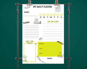 May include: A white daily planner sheet with black and yellow accents, held by a metal stand. The planner includes sections for name, tasks, a to-do list, and meal planning. The text "MY DAILY PLANNER" is at the top.
