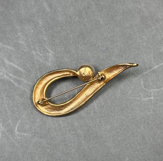 Vintage gold-colored Op Art brooch with a large glass bead. View 5