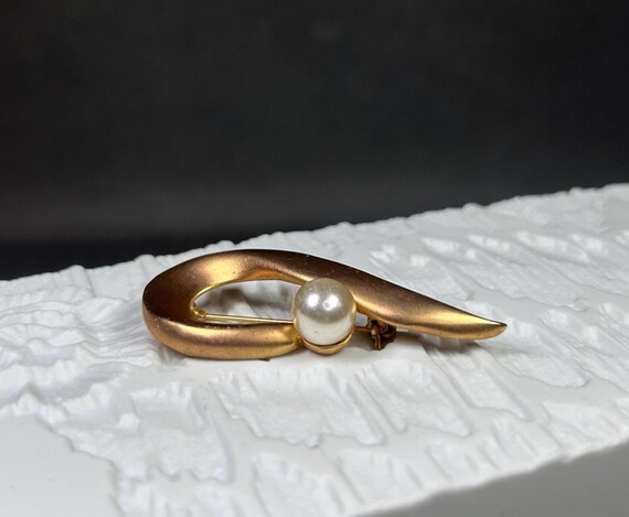 Vintage gold-colored Op Art brooch with a large glass bead. View 2