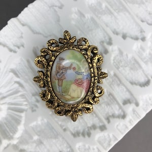 Vintage small porcelain brooch with romantic motif.