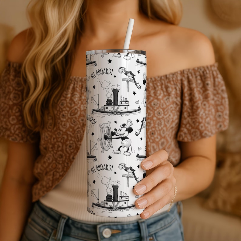 Puede incluir: Un vaso cil&iacute;ndrico blanco con un patr&oacute;n repetitivo en blanco y negro de un rat&oacute;n de dibujos animados al tim&oacute;n, un barco de vapor y un loro. El texto ALL ABOARD! est&aacute; impreso en negro. El vaso incluye una pajita blanca y una tapa met&aacute;lica.