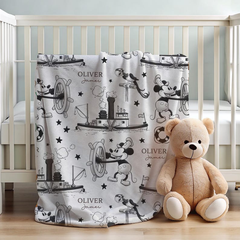 May include: A white fleece blanket featuring a black and white pattern of Mickey Mouse steering a steamboat, a parrot, life preservers, and stars. The text "OLIVER James" is printed in a script font throughout the repeating nautical design.