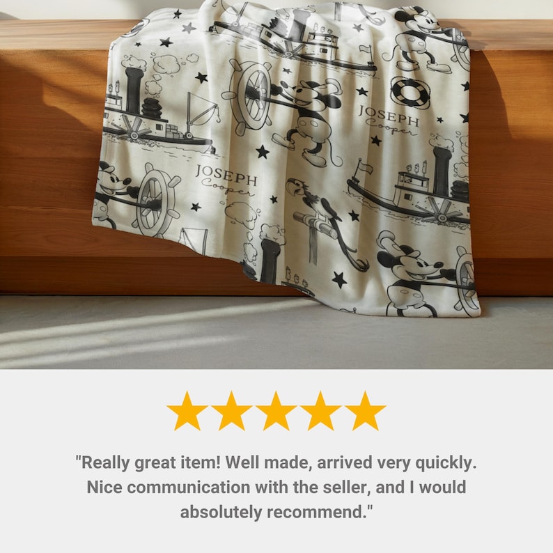 May include: A cream-coloured fleece blanket featuring a repeating black and white pattern of a cartoon mouse steering a steamboat, along with small stars and the printed text "JOSEPH Cooper". The design includes illustrations of a paddle steamer boat.