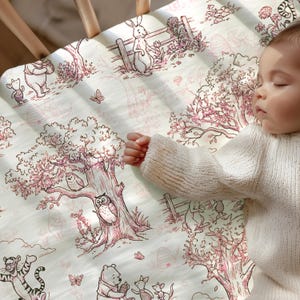 May include: A white crib sheet featuring a pink-toned line art illustration of Winnie the Pooh characters, including Tigger, Piglet, and owls in trees. The pattern includes butterflies, fences, and floral elements printed across the fabric surface.