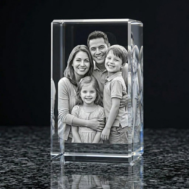 Puede incluir: Un bloque de cristal rectangular transparente con un retrato familiar en blanco y negro. La imagen muestra a una familia sonriente de cuatro miembros, padre, madre y dos hijos. El cristal refleja la luz. Un regalo personalizado &uacute;nico.