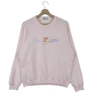 K&ouml;nnte beinhalten: Ein rosa Sweatshirt mit einem bunten "Courr&egrave;ges Paris" Logo auf der Vorderseite.