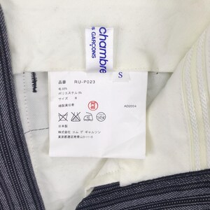 May include: White tag with blue text that reads "chambre S GAR&Ccedil;ONS" and "RU-P023". The tag also includes size, fabric content, care instructions, and manufacturer information in Japanese.