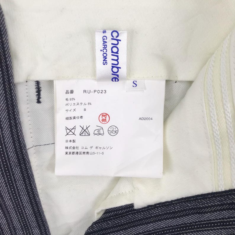 May include: White tag with blue text that reads "chambre S GAR&Ccedil;ONS" and "RU-P023". The tag also includes size, fabric content, care instructions, and manufacturer information in Japanese.