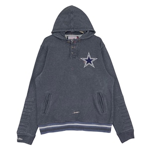 Puede incluir: Una sudadera con capucha gris oscuro con cuello abotonado y un bolsillo frontal grande. La sudadera presenta un logotipo de estrella blanca y azul en el pecho y detalles a rayas en la parte inferior. Las mangas tienen detalles acanalados.
