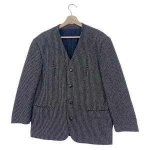 May include: A black and white striped blazer with a V-neck and button closure. The blazer has decorative stitching on the front and pockets.