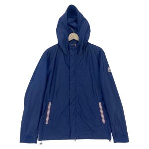 Puede incluir: Chaqueta con capucha azul marino con cremallera completa y dos bolsillos laterales. La chaqueta tiene un pequeño logotipo en la manga izquierda y un cordón en la parte inferior. Las cremalleras tienen rayas rojas y blancas.