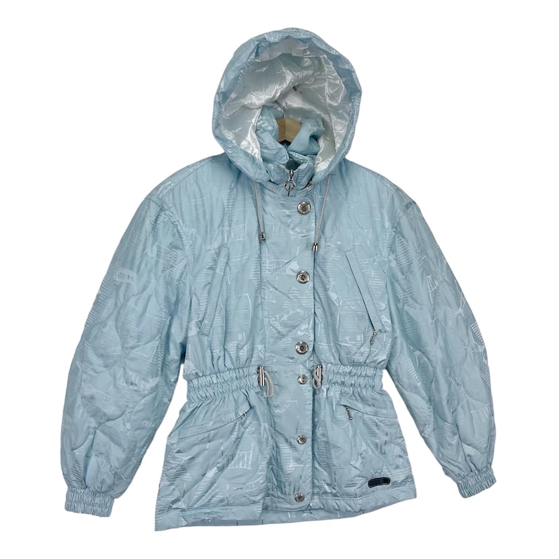 K&ouml;nnte beinhalten: Eine hellblaue Kapuzenjacke mit Kordelzug in der Taille und Knopfverschluss. Die Jacke hat ein dezentes Muster und einen silbernen Rei&szlig;verschluss.