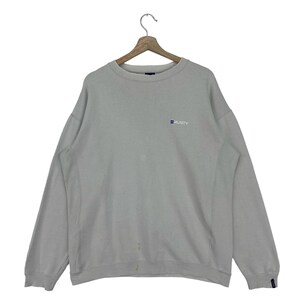 May include: A light gray sweatshirt with a small blue and white "RUSTY" logo on the front.