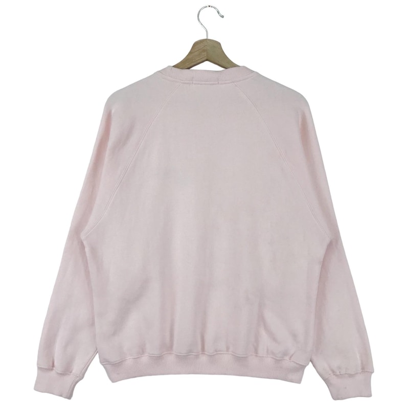 K&ouml;nnte beinhalten: Ein hellrosa Sweatshirt mit langen &Auml;rmeln und einem Rundhalsausschnitt.