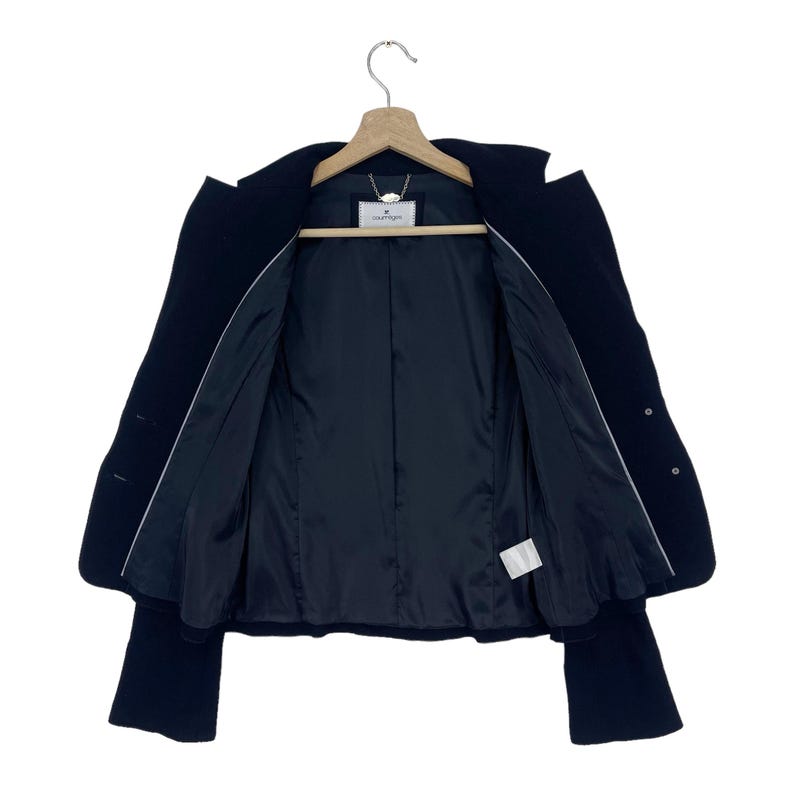 K&ouml;nnte beinhalten: Ein schwarzer Blazer mit wei&szlig;em Futter und einem kleinen wei&szlig;en Etikett mit dem Text "Couture" im Inneren.
