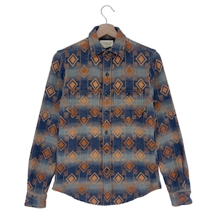 Könnte beinhalten: Ein langärmliges Hemd mit Knopfleiste und zwei Brusttaschen. Das Hemd ist mit einem geometrischen Muster in Blau und Orange bedruckt.