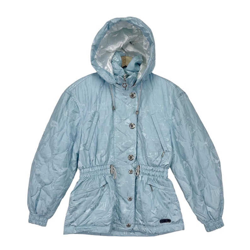 K&ouml;nnte beinhalten: Eine hellblaue Kapuzenjacke mit Kordelzug in der Taille und Knopfverschluss. Die Jacke hat ein dezentes Muster und einen silbernen Rei&szlig;verschluss.