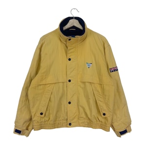 May include: A yellow jacket with a blue and white logo on the front and the text "Leyton House" on the sleeve.