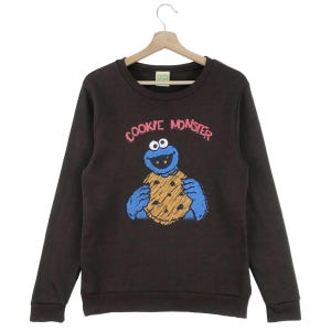 Może przedstawiać: Brązowa bluza z długimi rękawami z grafiką Cookie Monstera i napisem "Cookie Monster" w różowych i czarnych literach.