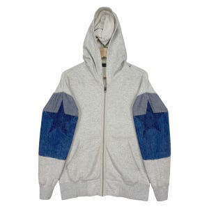 May include: A light gray zip-up hoodie with a hood and two front pockets. The sleeves feature denim patches with large blue star designs. The hoodie has a full-length zipper and ribbed cuffs and hem.