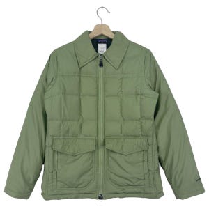May include: A green quilted jacket with a zipper closure and a large pocket on the front. The jacket has a collar and long sleeves. The label "patagonia" is visible on the front of the jacket.