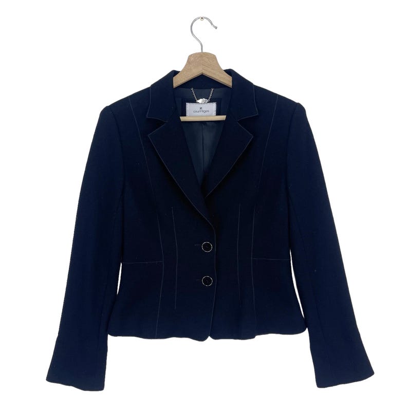 K&ouml;nnte beinhalten: Ein schwarzer Blazer mit einem einzigen Knopfverschluss und einem kleinen Etikett mit der Aufschrift "Valentino" auf der Innenseite.