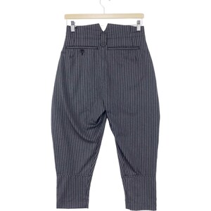 May include: Black and white striped pants with a high waist and a wide leg. The pants have a V-shaped waistband and a button closure.