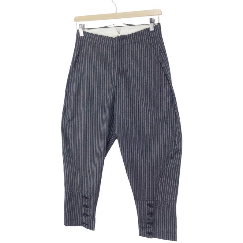 May include: Gray striped pants with a wide leg and a button detail at the bottom of each leg.