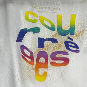 K&ouml;nnte beinhalten: Wei&szlig;es T-Shirt mit einer regenbogenfarbenen Grafik des Wortes "courr&egrave;ges" mit dem Text "sport futur" dar&uuml;ber.