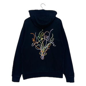 Puede incluir: Sudadera con capucha negra con un diseño abstracto de colores en la espalda.