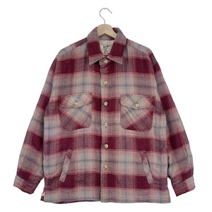 Op de afbeelding: Een rood en grijs geruit flanellen overhemd met twee borstzakken en twee onderste zakken. Het overhemd heeft een knoopsluiting aan de voorkant en een kraag. Het overhemd is gemaakt van een zachte, geweven stof.