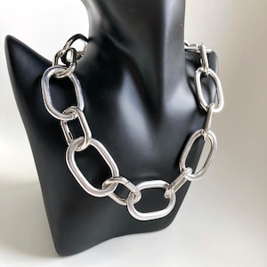 Peut inclure: Un collier chaîne argenté épais avec de gros maillons ovales.