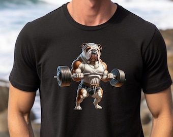 May include: A black t-shirt with a graphic of a bulldog lifting weights. The bulldog is wearing a white tank top and a bandage on its head. The text "Bella Canvas 3001" and "Black" is printed on the bottom of the shirt.